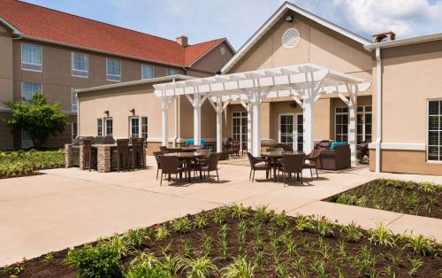 a patio with tables and chairs in front of a building at Homewood Suites by Hilton St. Louis Riverport- Airport West in Maryland Heights