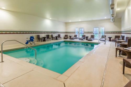 - une piscine dans une chambre d'hôtel dotée de tables et de chaises dans l'établissement Homewood Suites by Hilton St. Louis Riverport- Airport West, à Maryland Heights