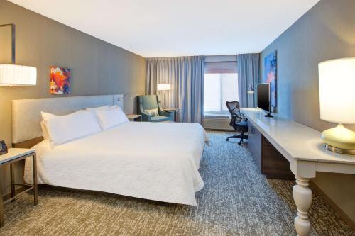 a hotel room with a large bed and a desk at Hilton Garden Inn Chesterton in Chesterton