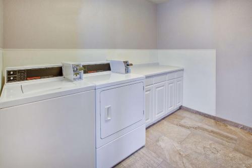 a white laundry room with a washer and dryer at Hilton Garden Inn Chesterton in Chesterton