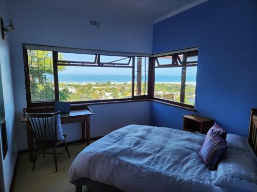 1 dormitorio con cama, escritorio y ventana en iGolomi Hillside Cottage, en George