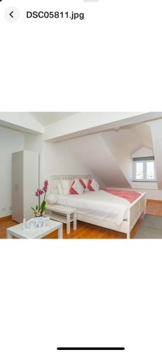 a bedroom with a white bed and a table at Faustina's place in Portimão