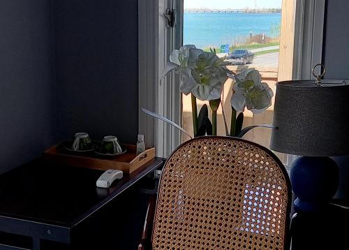 uma secretária com uma cadeira e uma janela com um vaso de flores em WaterfrontHome-RiverView, Windsor ,Canada em Windsor