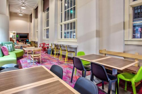a cafeteria with wooden tables and chairs and tables and chairs at Home2 Suites by Hilton San Antonio Downtown - Riverwalk, TX in San Antonio