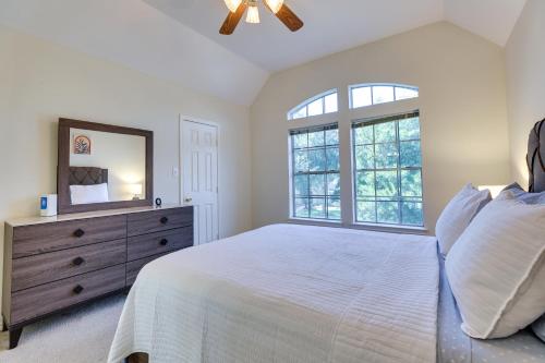 a bedroom with a bed and a dresser with a mirror at Spacious Sugar Land Retreat with Fireplace and Yard in Sugar Land