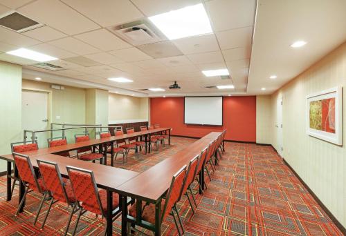 a conference room with tables and chairs and a screen at Home2 Suites by Hilton San Antonio Downtown - Riverwalk, TX in San Antonio