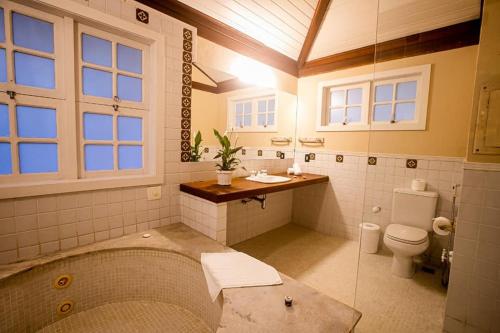 a large bathroom with a tub and a toilet at Villa Don in Petrópolis