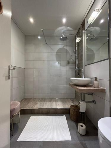 ein Bad mit einem Waschbecken und einem Spiegel in der Unterkunft Wohnen am Schloss in Wolfsburg