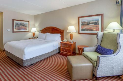 a hotel room with a bed and a chair at Hilton Garden Inn Richmond South/Southpark in Colonial Heights