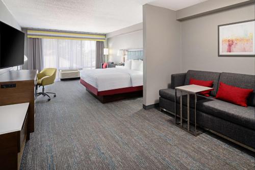 a hotel room with a bed and a couch at Hampton Inn Richmond/Midlothian Turnpike in Midlothian
