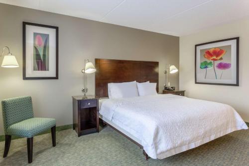 a hotel room with a bed and a chair at Hampton Inn Richmond - South in Richmond