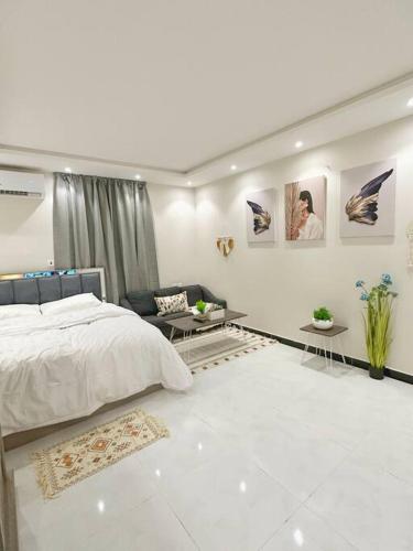 a white bedroom with a bed and a couch at ستوديو البوليفارد مدخل جانبي h3 in Riyadh