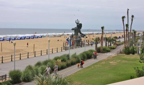 a beach with a statue of a lion and people riding bikes at Hampton Inn Virginia Beach Oceanfront North in Virginia Beach