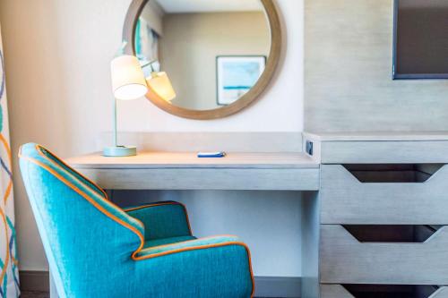 a dressing table with a mirror and a blue chair at Hampton Inn Virginia Beach Oceanfront North in Virginia Beach