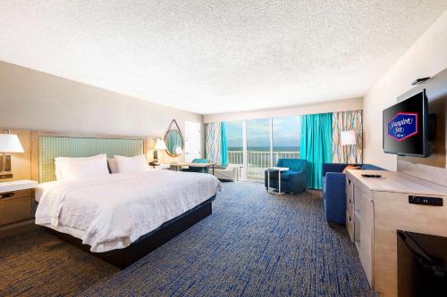 a hotel room with a bed and a flat screen tv at Hampton Inn Virginia Beach Oceanfront North in Virginia Beach