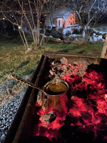 a pot sitting on top of a fire with red pigment at Phalesia Glamping Otel in Sapanca