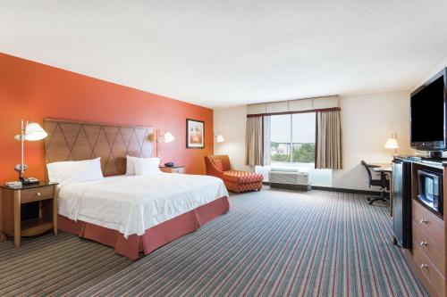 a hotel room with a bed and a flat screen tv at Hampton Inn Petersburg - Southpark Mall in Colonial Heights