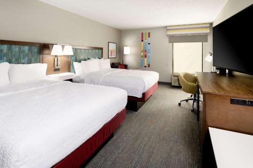 a hotel room with two beds and a desk at Hampton Inn Richmond-SW Hull Street in Midlothian