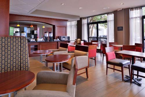 a restaurant with tables and chairs and a bar at Hampton Inn Norfolk/Virginia Beach in Virginia Beach