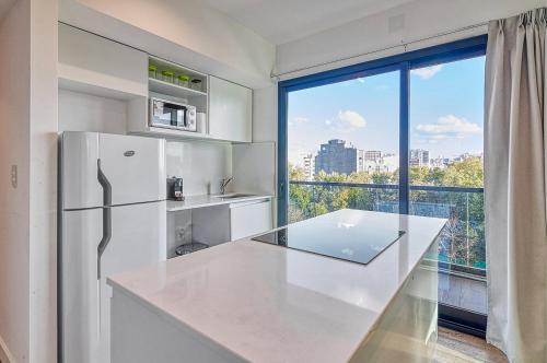 Una cocina con un refrigerador blanco y una ventana grande. en Live Soho Boutique Apartments Belgrano, en Buenos Aires