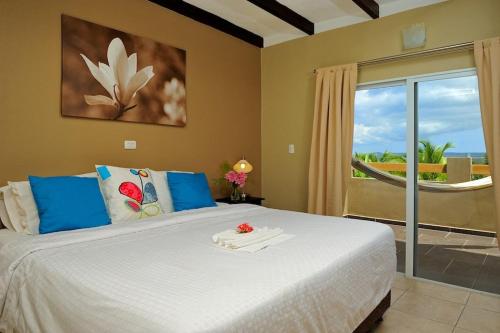 a bedroom with a bed with a view of the ocean at Eden Beach Resort - Bonaire in Kralendijk