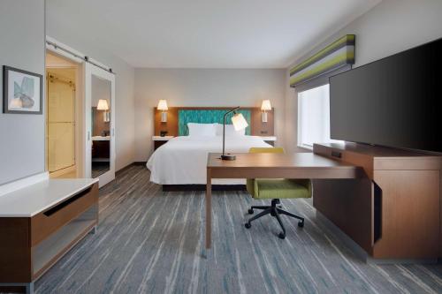 um quarto de hotel com uma cama e uma secretária com um computador em Hampton Inn & Suites Richmond Short Pump, Va em Richmond
