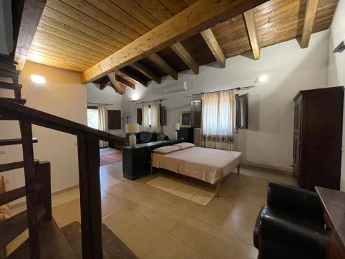 a bedroom with a bed and a living room at S'Abba Druche rooms in Bosa
