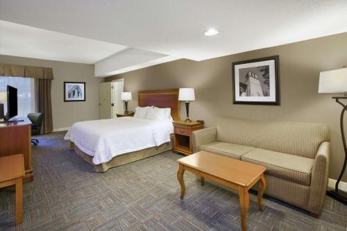 a hotel room with a bed and a couch at Hampton Inn Richmond-West Innsbrook in Broad Meadows