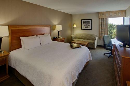 a hotel room with a bed and a flat screen tv at Hampton Inn Richmond-West Innsbrook in Broad Meadows