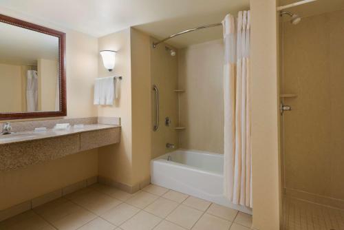 y baño con bañera, lavamanos y ducha. en Hilton Garden Inn Washington DC/Greenbelt, en Greenbelt