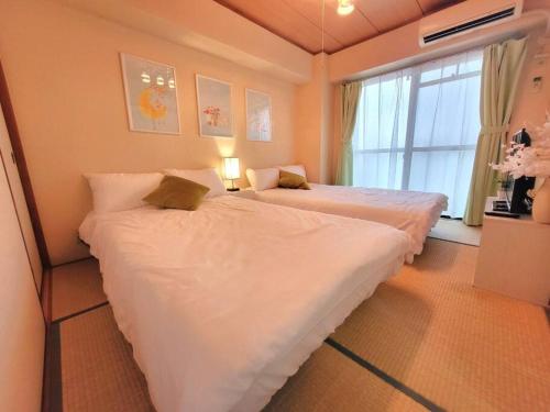 大阪的住宿－Two room house in front of namba f201，带窗户的客房内设有两张单人床。