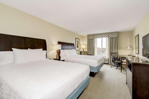 a hotel room with two beds and a desk at Hilton Garden Inn Waldorf in Waldorf