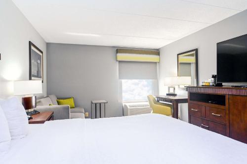 a hotel room with a bed and a living room at Hampton Inn Lexington Park in Lexington Park
