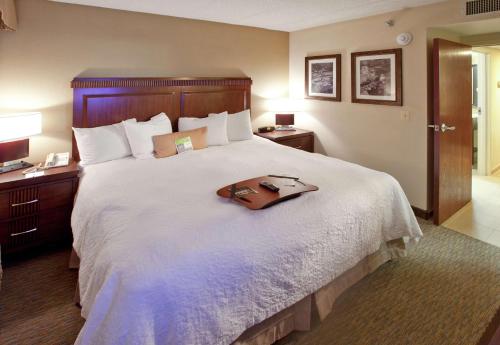 ein Hotelzimmer mit einem großen Bett mit einer Tasche darauf in der Unterkunft Hampton Inn Lexington Park in Lexington Park