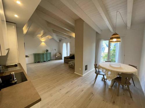 een grote woonkamer met een tafel en een keuken bij Appartamento Ginepro in Pian dei Pradi
