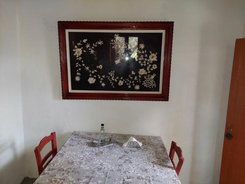 uma mesa com duas cadeiras e uma foto na parede em Tree house nikiforos em Kissamos