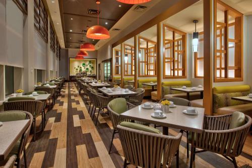 a dining room with tables and chairs and windows at Hilton Garden Inn Virginia Beach Oceanfront in Virginia Beach