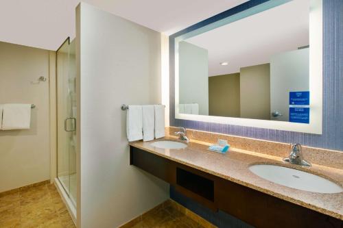 un bagno con due lavandini e un grande specchio di Hilton Garden Inn Virginia Beach Oceanfront a Virginia Beach