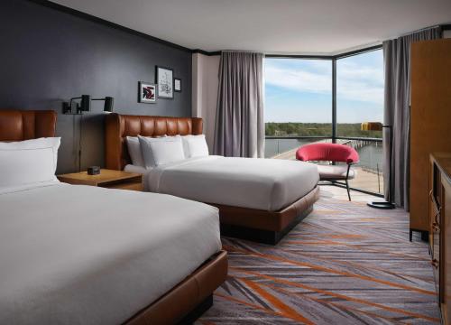 a hotel room with two beds and a balcony at The Landing at Hampton Marina, Tapestry Collection by Hilton in Hampton