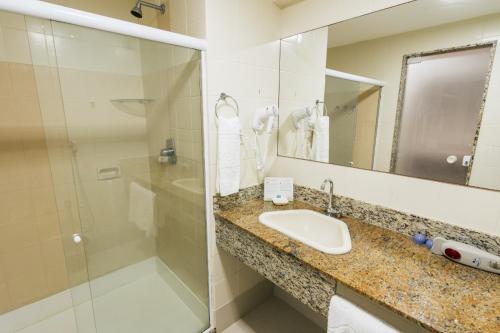 a bathroom with a sink and a shower at Resort Costa Dos Coqueiros in Imbassai