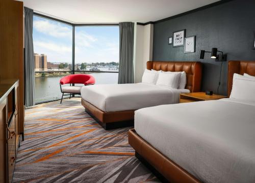 a hotel room with two beds and a large window at The Landing at Hampton Marina, Tapestry Collection by Hilton in Hampton