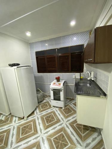 una pequeña cocina con nevera y microondas en Pousada Atlântico tambaú Flat, en João Pessoa