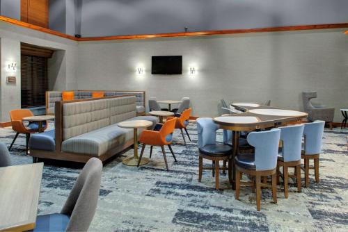 a restaurant with tables and chairs and a tv at Homewood Suites by Hilton Richmond - West End / Innsbrook in Broad Meadows