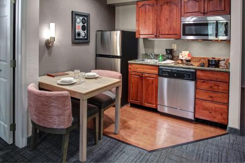 a kitchen with a table with chairs and a refrigerator at Homewood Suites by Hilton Richmond - West End / Innsbrook in Broad Meadows