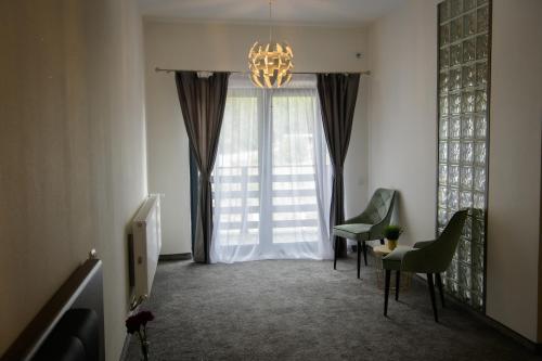une chambre avec des chaises et une fenêtre avec un lustre dans l'établissement Hotel Vegas Negreni, à Negreni