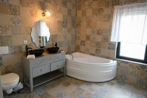 a bathroom with a tub and a toilet and a sink at Hotel Vegas Negreni in Negreni