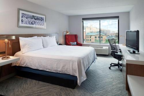 底特律的住宿－底特律市區希爾頓花園旅館，配有一张床、一张书桌和一扇窗户的酒店客房