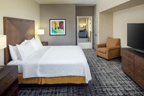 a hotel room with a large bed and a television at Embassy Suites by Hilton Laredo in Laredo