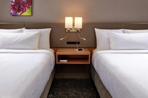 a hotel room with two beds and a side table at Hilton Garden Inn Portland Lake Oswego in Lake Oswego