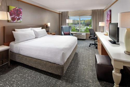 a hotel room with a bed and a desk at Hilton Garden Inn Portland Lake Oswego in Lake Oswego
